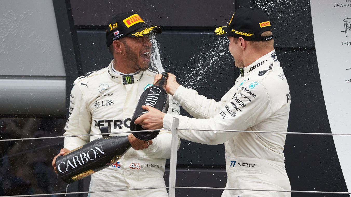 L'immagine mostra i due piloti Mercedes-AMG di Formula 1 mentre festeggiano la vittoria.