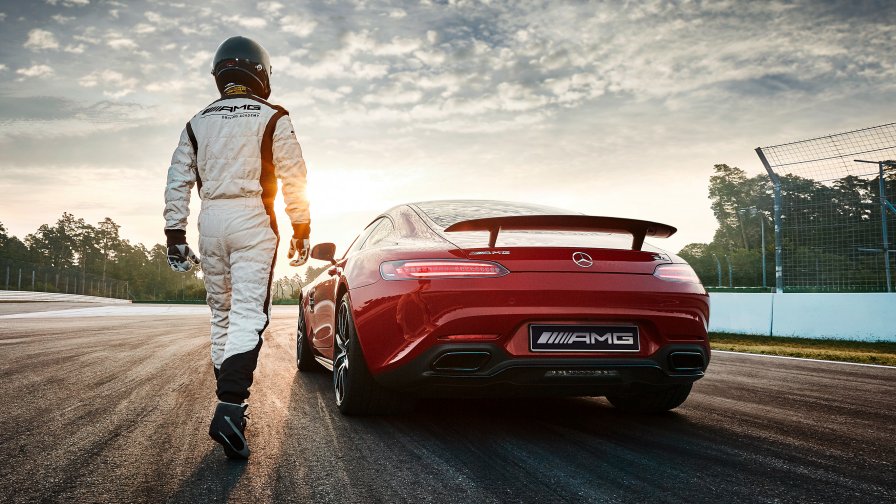 L'immagine mostra un pilota che si dirige verso la sua Mercedes-AMG GT S rossa.